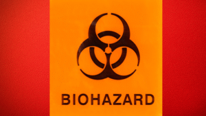 Close-up image of a red barrel with a large, orange biohazard sign and symbol